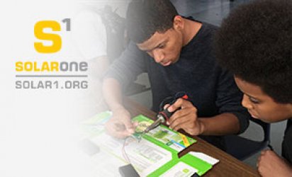 Thumbnail photo of two students working at desk with what appears to be electrical wire they they are testing or soldering. The Solar One logo is at the top right of the photo overa feathered white background.